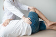 © nBhutinat - Therapist treating test the strength of the hip muscles of male patient.