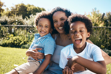 Sticker - Excited little boy with afro sitting outside on the grass with his mother and brother. Energetic african american family spending time outdoors at the park or their backyard. Mom embracing two sons