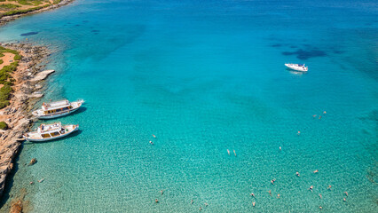 Canvas Print - Aerial view of tourist boats and swimmers in crystal clear waters off a small beach (Kolokitha, Crete, Greece)