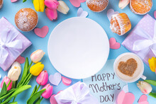 Mother's Day Holiday Greeting Card. Mother's Day Morning Breakfast With A Cute Surprise Background, With Gift Boxes, Cupcakes, Coffee Mug, Heart Decor, Tulips And Flowers, Happy Mother's Day Letter
