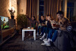 © master1305 - Winning match. Group of sport fans, friends sitting on couch at home in the evening and watching american football game translation on tv. Concept of friendship, leisure activity, weekends, emotions