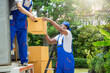 © visoot - Two removal company workers are unloading boxes from a mini truck into new home.