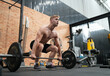 © FotoArtist - Man doing weight lifting exercises inside the gym
