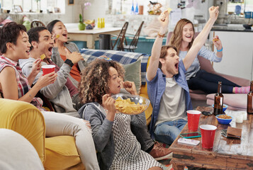 Thats our team. Shot of a group of friends enjoying snacks and drinks while watching something.