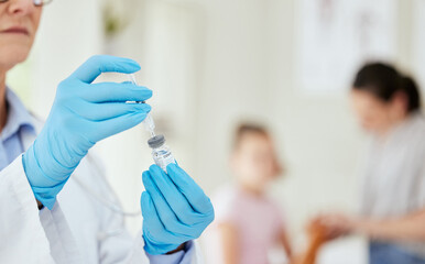 Wall Mural - protection in a vial. shot of an unrecognizable doctor preparing a vaccine at a hospital.
