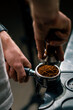 © Guys Who Shoot - A professional barista in a coffee shop prepares ground coffee by tamping fresh ground coffee beans close-up