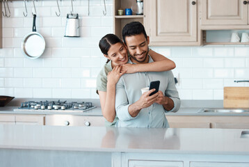 Canvas Print - What are you up to. Shot of a young couple using a phone together at home.