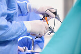 Fototapeta Lawenda - Operacja laparoskopowa na sali operacyjnej w szpitalu. Dłonie chirurga w sterylnych rękawiczkach trzymają narzędzia endoskopowe. Asysta instrumentariuszki.