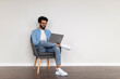 © Prostock-studio - Freelance Career. Smiling Indian Man Using Laptop Computer While Sitting In Chair