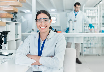 Science is the world I love getting lost in. Portrait of a young scientist sitting with her arms crossed in a lab.