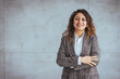 © Dragana Gordic - Portrait of young smiling woman looking at camera with crossed arms. Happy girl standing in creative office. Successful businesswoman standing in office with copy space.