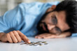 © Prostock-studio - Poverty And Absence Of Money. Upset Indian Man Counting Coins On Table