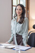 © David - Happy young business Asian woman posing isolated over grey office background.