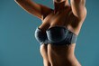 © vladimirfloyd - Close up on woman torso in the shadow. Blue bra and natural breasts cleavage on a blue background