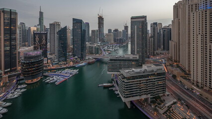 Wall Mural - Aerial view to Dubai marina skyscrapers around canal with floating boats day to night timelapse