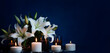Mourning flowers white lilies and candles on a dark background in the form of a bouquet for condolences, generated by ai