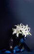 Mourning flowers white lilies on a dark background in the form of a bouquet for condolences, generated by ai