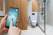 © Angelov - Hand holding smart phone with home control application with water detected, Smart home concept.