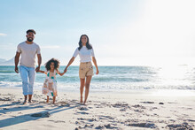 A Walk In The Sunshine. Full Length Shot Of An Affectionate Young Family Of Three Taking A Walk On The Beach.