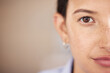 Closeup of mixed race womans eye and face with freckles split in half looking straight ahead at the camera. One female only staring in front of her. Confident woman focused on her goals and vision