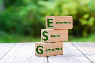 Wall Mural - Words ESG on a wood block on soil natural green background. ESG concept of environmental, social and governance idea for sustainable modernization development.