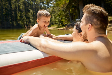 Sticker - Hes having a blast. Cropped shot of an affectionate young family of three having fun in the lake.