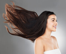 Care For More Than Just The Surface. Studio Shot Of A Beautiful Young Woman With Flowing Hair Against A Grey Background.