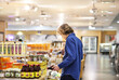 © lado2016 - Young man shopping in supermarket, reading product information