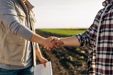 two man shaking hands in the field. closeup view of hands shaking.