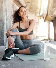 Wall Mural - Taking a moment to enjoy the city views. Full length shot of an attractive young woman sitting alone during her outdoor workout.