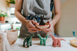 Leinwandbild Motiv Young woman holding ceramic dinosaur figurines