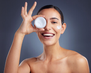 Wall Mural - Its all in the moisturiser. Studio shot of a beautiful woman holding up a skincare product.