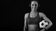 © Anastasia.photoyoga - Confident sport happy smiling woman standing in sport bra and holding basketball ball in wireless headphones on studio background with empty copy space. Front view. Closeup banner portrait.