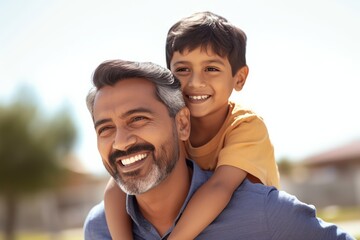 Wall Mural - Happy smiling father giving son ride on back