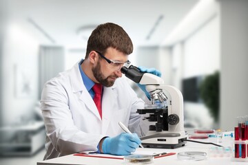  Young male researcher works with microscope at laboratory.