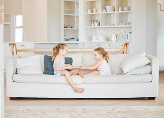 Canvas Print - Sharing is caring. Shot of two little sisters fighting over a digital tablet at home.