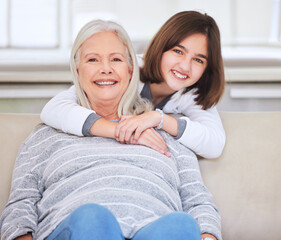 Wall Mural - Precious time spent in love. Shot of a mature woman bonding with her grandchild on a sofa at home.