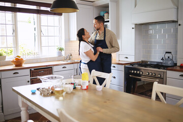 Wall Mural - Living the sweet life. Shot of an affectionate couple dancing while baking together at home.