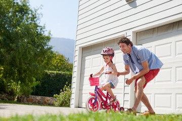 Sticker - I believe in your skills. Shot of a young father teaching his daughter to ride a bike.