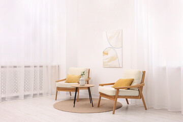 Canvas Print - Stylish armchairs and wooden table in living room. Interior design