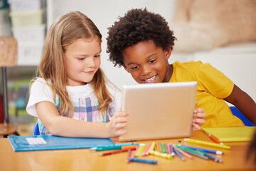 kids love to learn. shot of two preschool students looking at something on a digital tablet together