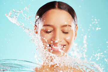 Wall Mural - Smell good, look good. Shot of an attractive young woman showering against a blue background.