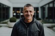 © Eber Braun - Portrait of a happy mature man in a black jacket outdoors.