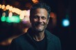 © Hanne Bauer - Portrait of a smiling middle-aged man in the city at night