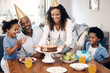 © A. Frank/peopleimages.com - African american family celebrating birthday at home. Mom putting birthday cake with candles on table. . Two little boys and their parents wearing party hats and looking excited