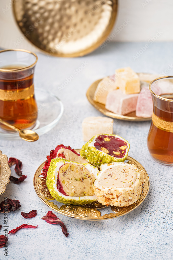 Plate with tasty Turkish Delight on light background