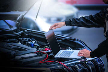 computer diagnostics of the car in garage. automotive mechanical technician using laptop computer pr