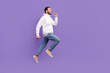 © deagreez - Full length body image photo of young hispanic man wear hoodie with denim walking empty space adventures isolated on purple background