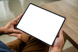 Fototapeta Panele - A businessman holds a mockup. iPad digital tablet with blank screen Mockup replaces your design mockup in the office.