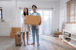 Happy Asian couple moving into their new home.